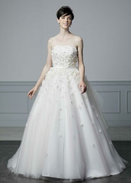 Abito da sposa in tulle con fiori di stoffa che adornano sia il corpetto che la gonna di questo vestito