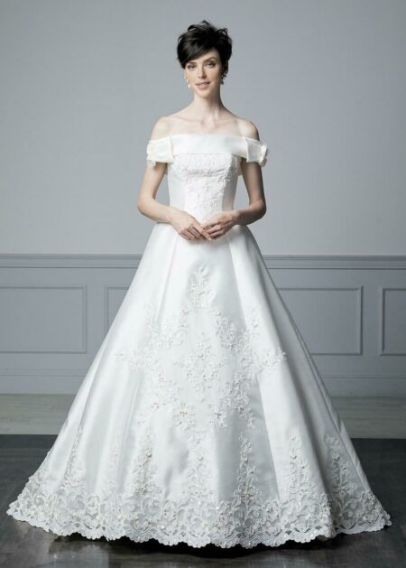 Abito da sposa non convenzionale in raso con bustino semirigido e preformato, gonna impreziosita da un grande fiore di stoffa sulla schiena e volants di organza