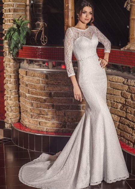 Abito da sposa di classe stile sirena fatto interamente di pizzo con maniche tre quarti semitrasparenti, strascico corto