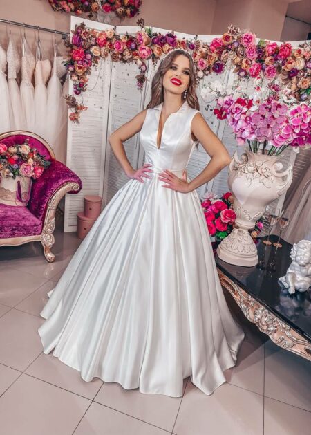 Abito da sposa con collo alla coreana molto romantico fatto in raso con gonna ampia e un leggero strascico corto