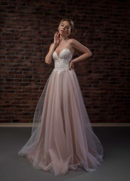 Abito da sposa con gonna in tulle colore cipria, impreziosito da un corpetto stretto in pizzo dallo scollo a cuore, reggiseno interno
