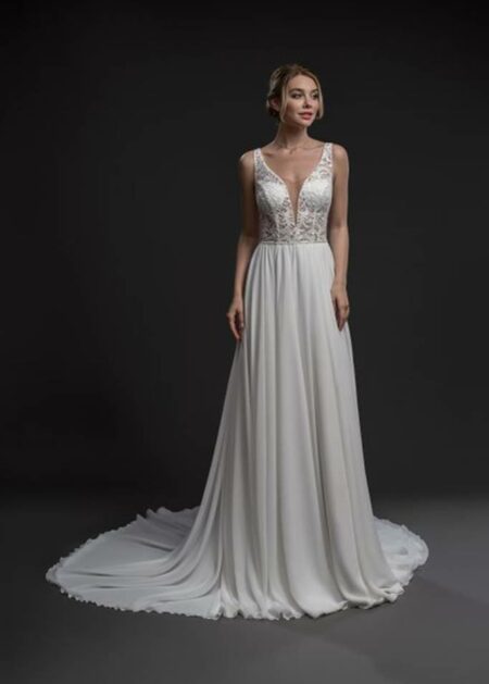 Abito da sposa dal taglio sobrio e sofisticato valorizzato dall’impiego di tessuti esclusivi come il chiffon e pizzo con scollo a V